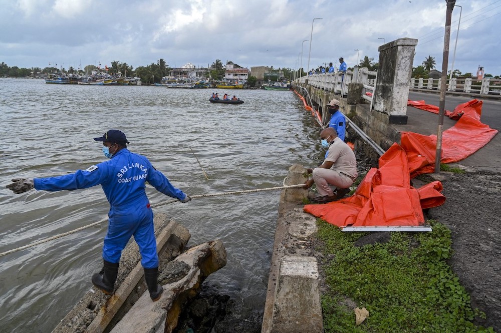 Sri Lankan Coast Guard personnel lay booms at an estuary in Negombo, north of Sri Lankan capital Colombo on May 28, 2021. — AFP pic