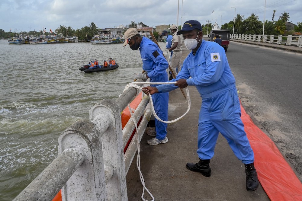 Sri Lankan Coast Guard personnel lay booms at an estuary in Negombo, north of Sri Lankan capital Colombo on May 28, 2021. u00e2u20acu201d AFP picnn