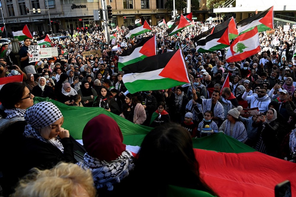 Protesters wave Palestinian flags during a demonstration against Israel at the Town Hall in Sydney on May 15, 2021, amid the ongoing conflict between Israel and the Palestinian Territories. u00e2u20acu2022 AFP picnn