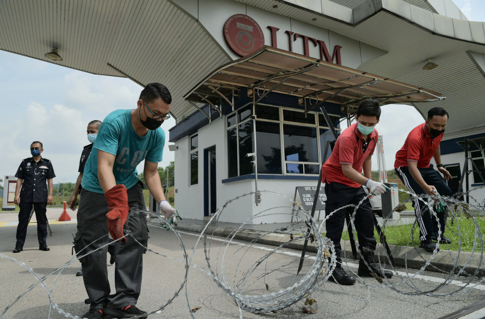 UTM Skudai security personnel along with the police install barbed wire at gate 2 of the university, May 20, 2021. u00e2u20acu201d Bernama pic 