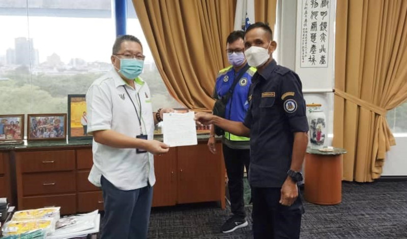 An enforcement officer from Kuching South City Council issuing a compound to Datuk Wee Hong Seng at his office, May 18, 2021. u00e2u20acu201d Picture from Datuk Wee Hong Sengu00e2u20acu2122s Facebookn
