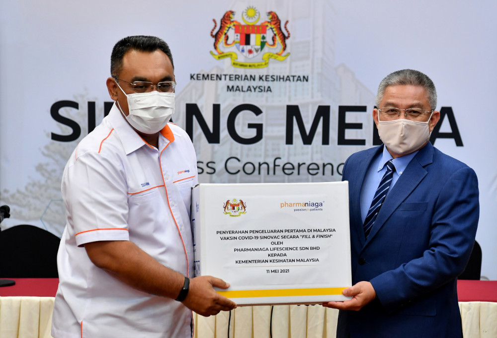 Health Minister Datuk Seri Dr Adham Baba receiving the Sinovac vaccines from Pharmaniaga Bhd managing director Datuk Zulkarnain Md Eusope in Putrajaya, May 11, 2021. u00e2u20acu201d Bernama pic 