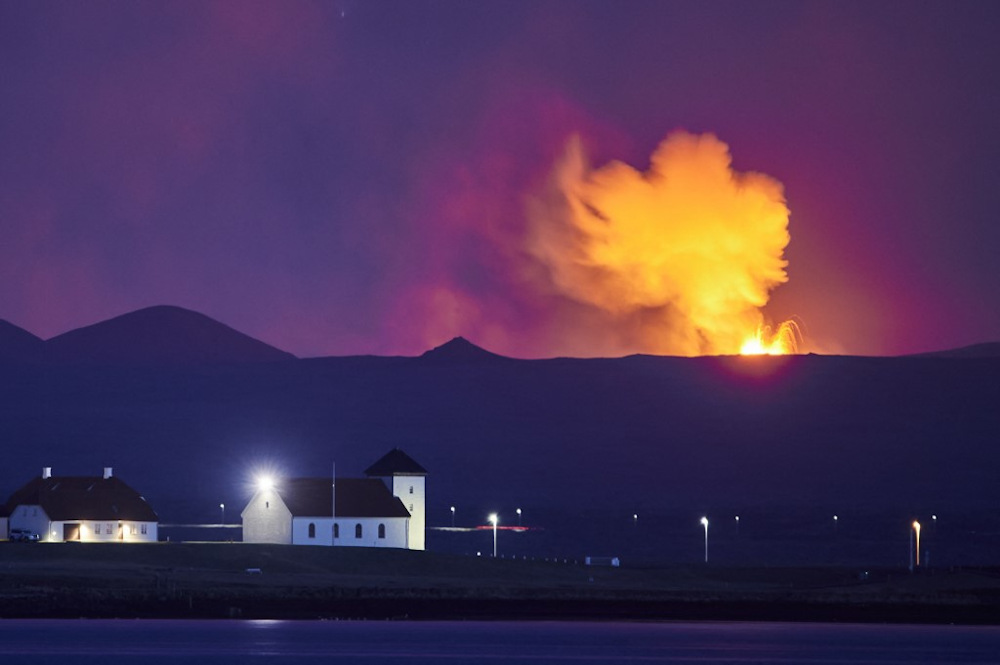 This file photo taken on May 5, 2021 shows Bessastadir, the official residence of the President of Iceland, seen from Reykjavik, with the glow from the lava coming out of a fissure near the Fagradalsfjall on the Reykjanes Peninsula behind. u00e2u20acu201d AFP pic