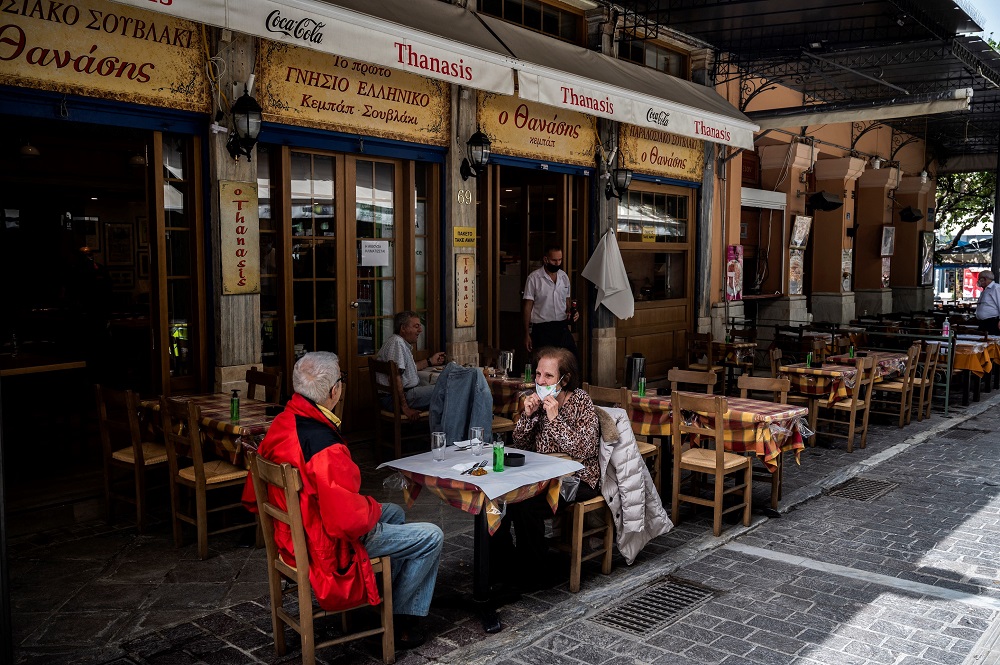 People sit at a restaurant's terrace on Monastiraki square in Athens. u00e2u20acu2022 AFP pic via ETX Studio