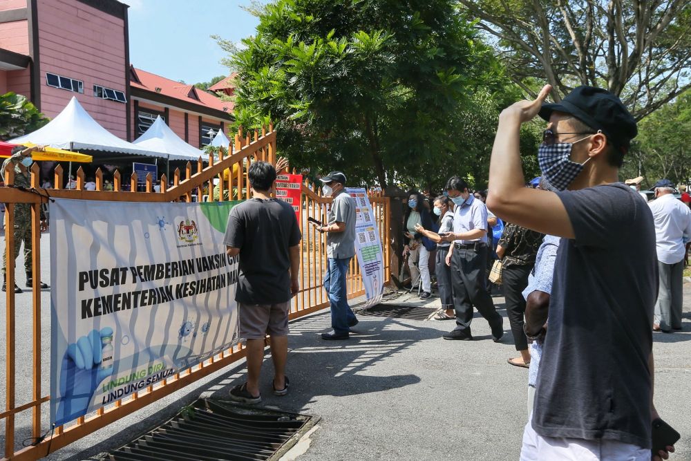 People wait to receive the Covid-19 vaccine outside the Bandar Sri Menjalara community hall in Kuala Lumpur May 25, 2021. u00e2u20acu2022 Picture by Ahmad Zamzahurinn