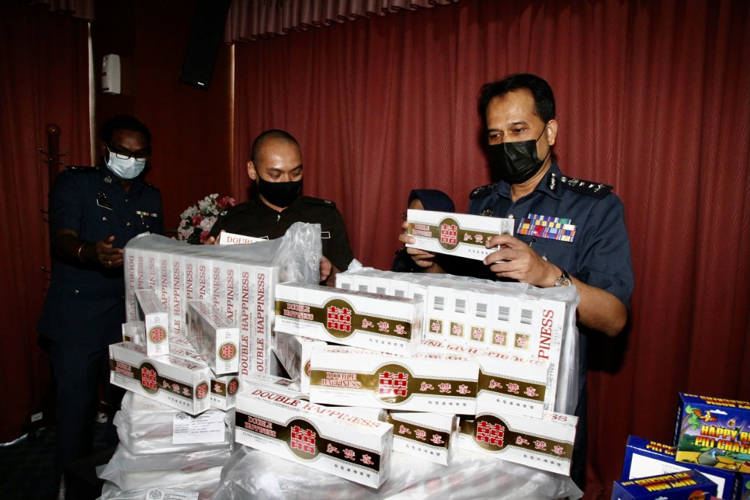 Johor Customs Department director Sazali Mohamad (far right) with part of the 257,400 untaxed cigarettes estimated to be worth RM61,776 that were found inside fish barrels earlier this month. u00e2u20acu201d Picture by Ben Tannn