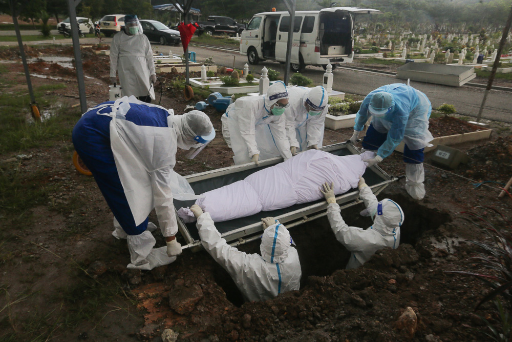 Workers and family members wearing protective suits bury a victim of the Covid-19 disease at a cemetery in Shah Alam May 18, 2021. u00e2u20acu201d Picture by Yusof Mat Isa