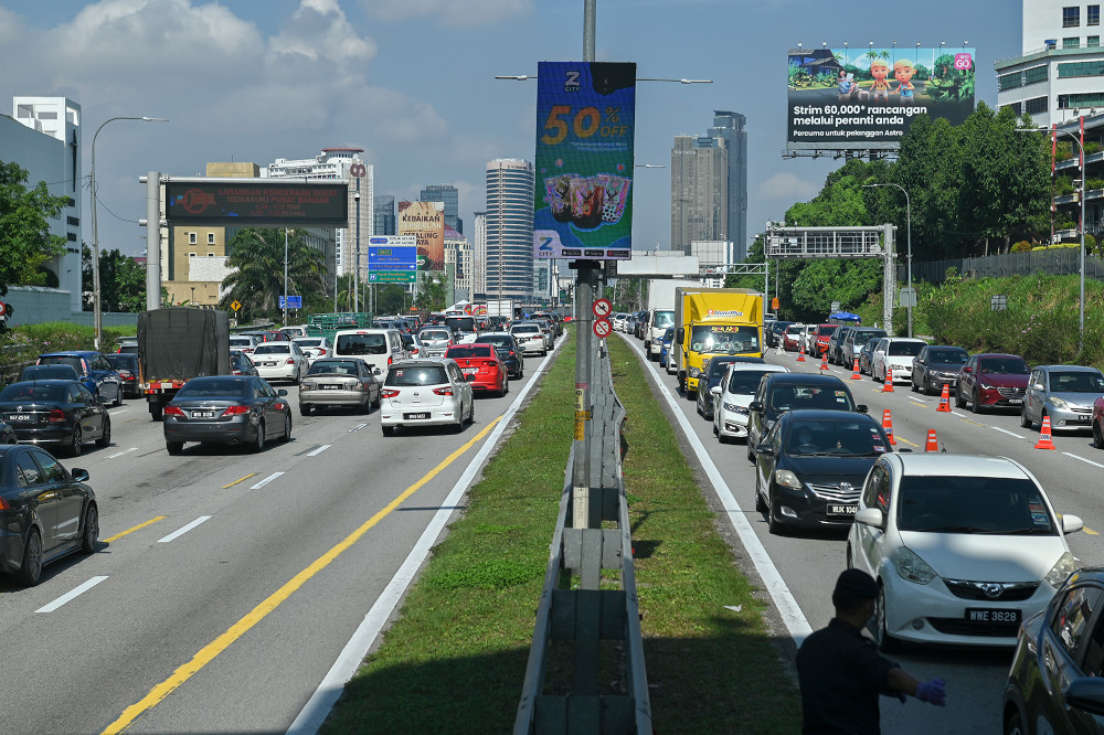 Police officers conducting roadblock checks during movement control order 3.0 (MCO) on the Federal Highway May 10, 2021. u00e2u20acu201d Picture by Miera Zulyana