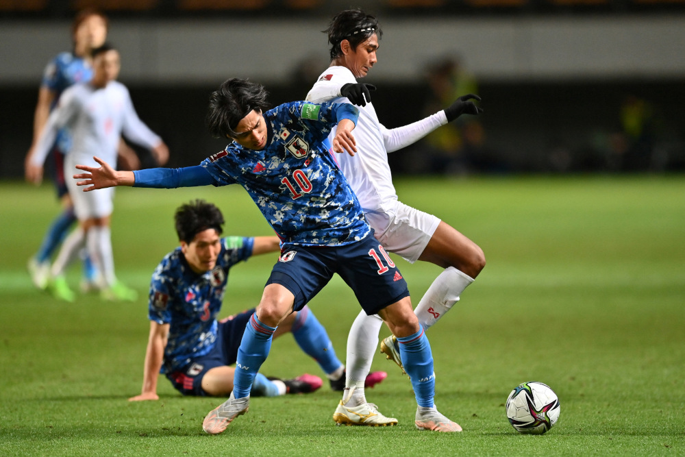 Japanu00e2u20acu2122s midfielder Takumi Minamino (left) fights for the ball with Myanmaru00e2u20acu2122s defender Hein Htet Sithu during the Fifa World Cup Qatar 2022 Asian zone group F qualification football match between Japan and Myanmar at Fukuda Denshi arena in Chiba May 28