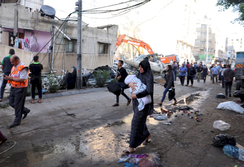People walk past debris in a street at the site of Israeli air strikes, in Gaza City May 16, 2021. u00e2u20acu201d Reuters pic