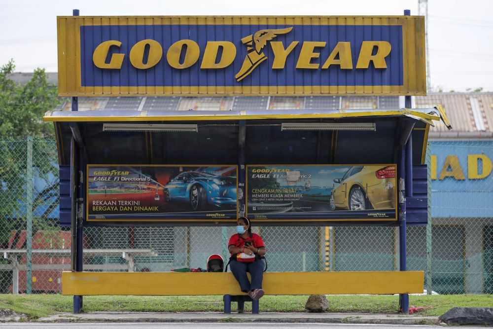 A woman sits at a bus stop outside Goodyear factory in Shah Alam May 6, 2021. u00e2u20acu201d Reuters pic