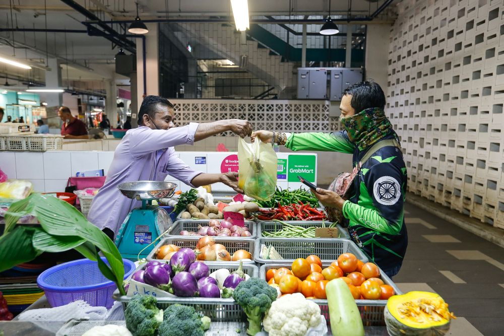 A GrabFood rider picks up his customeru00e2u20acu2122s groceries at the Chowrasta Market in George Town May 11, 2021. u00e2u20acu201d Picture by Sayuti Zainudinnn
