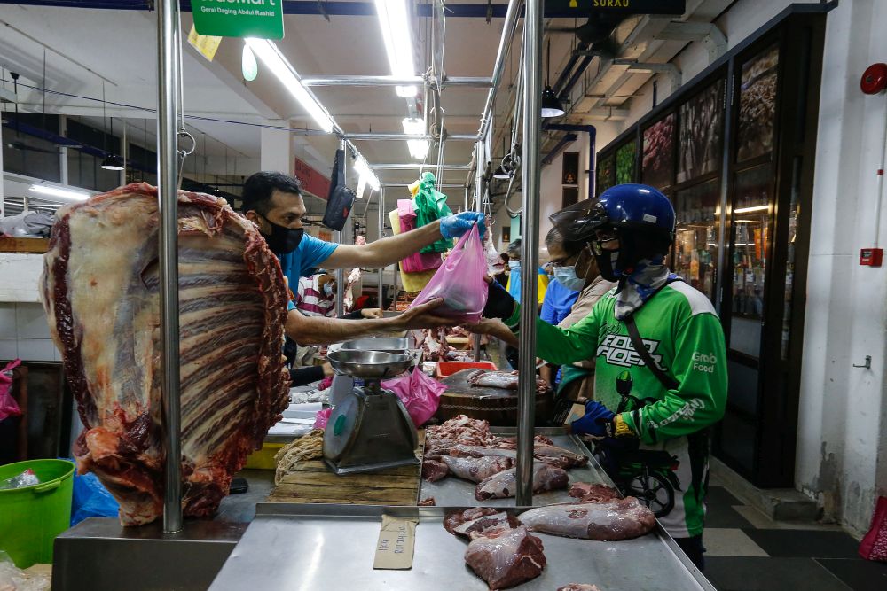 A GrabFood rider picks up his customer’s groceries at the Chowrasta Market in George Town May 11, 2021. — Picture by Sayuti Zainudin