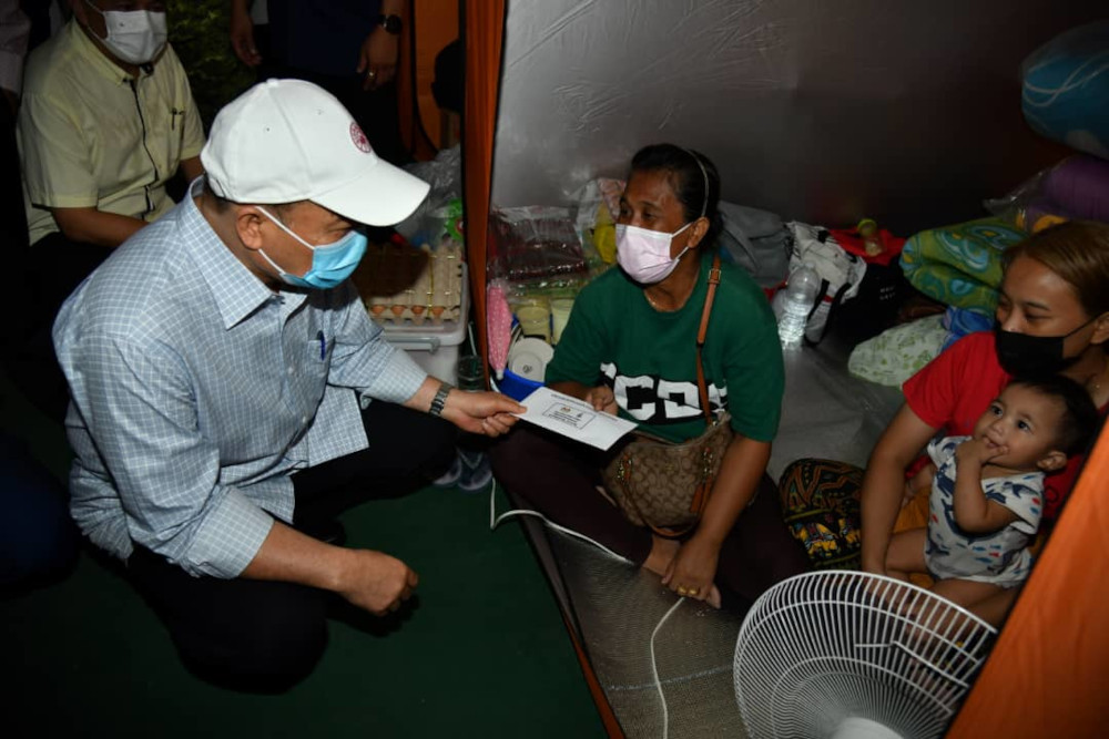 Sabah Chief Minister Datuk Hajiji Noor meeting some of the victims of the fire in Kampung Meruntum last Saturday which saw 35 wooden stilt homes razed. u00e2u20acu201d Picture by Julia Chan
