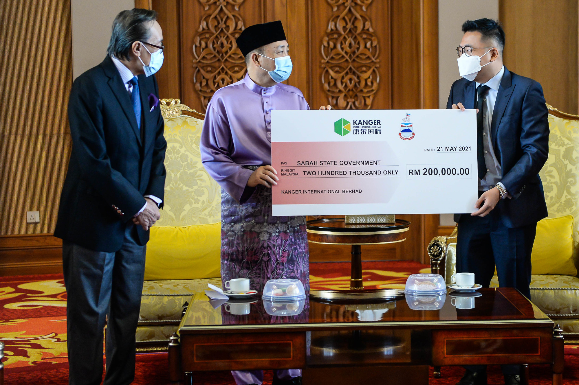 Chief Minister Datuk Seri Hajiji Noor receiving the replica cheque from Kanger International Bhd Executive Director Steven Kuah (right) at PPNS, May 21, 2021. u00e2u20acu201d Picture courtesy of the Sabah Chief Ministeru00e2u20acu2122s Office 