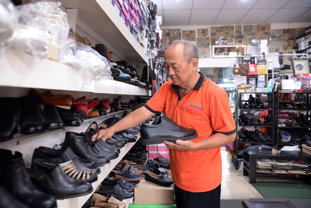 Wong arranges shoes for display at his shop. — Picture by Steven Ooi KE