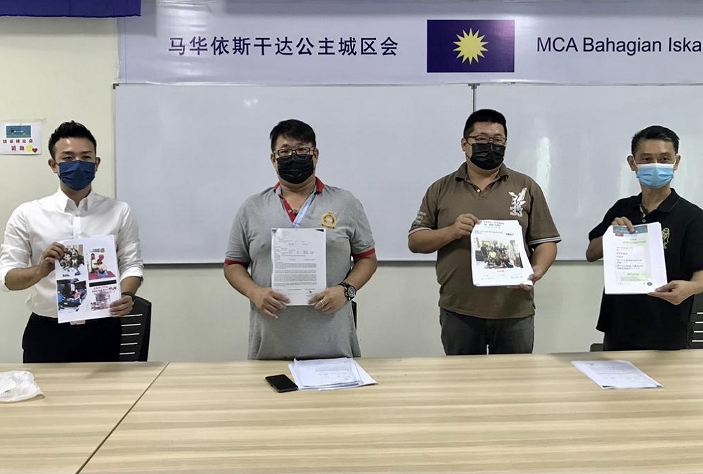 Trader Ng Chen Yuan (second, left) shows the police reports that he lodged during a media conference at the Gelang Patah MCA division office in Iskandar Puteri May 18, 2021. u00e2u20acu201d Picture by Ben Tan