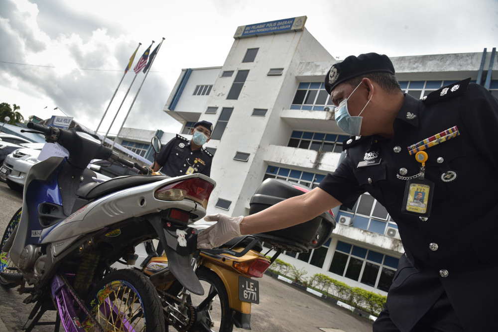 Labuan police chief Supt Ahmad Jawila with one of the seized motorcycles at the Labuan police station, May 18, 2021. u00e2u20acu201d Bernama pic 