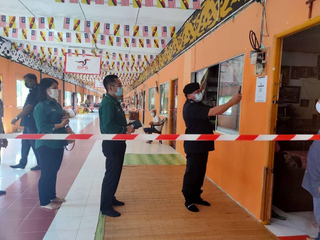 Jame (right), accompanied by Calvin behind him), scans his MySejahtera apps during a surprise check at Rumah Mat Sampei. u00e2u20acu2022 Borneo Post pic