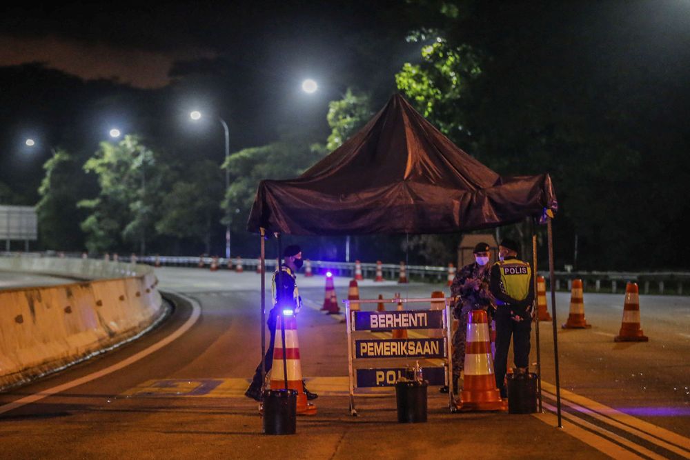 Police and the Malaysian Armed Forces personnel wait to inspect vehicles during a roadblock at the Gombak Toll Plaza, Selangor May 5, 2021. u00e2u20acu201d Picture by Hari Anggarann