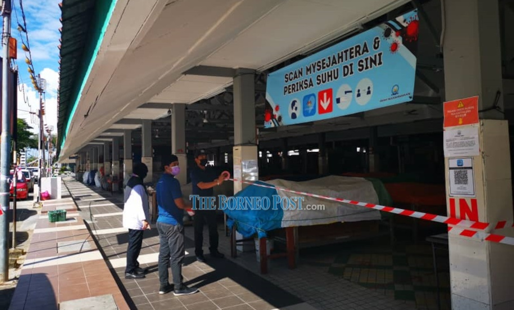 Council workers sealing off the entrance at the Miri Central Market on May 24. u00e2u20acu201d Borneo Post Online pic