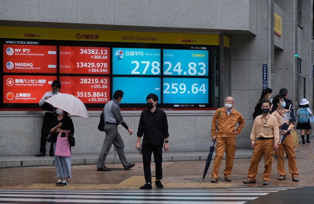 People stand in front of an electronic quotation board displaying the closing numbers of share price at the Tokyo Stock Exchange in Tokyo, May 17, 2021. u00e2u20acu201d AFP pic