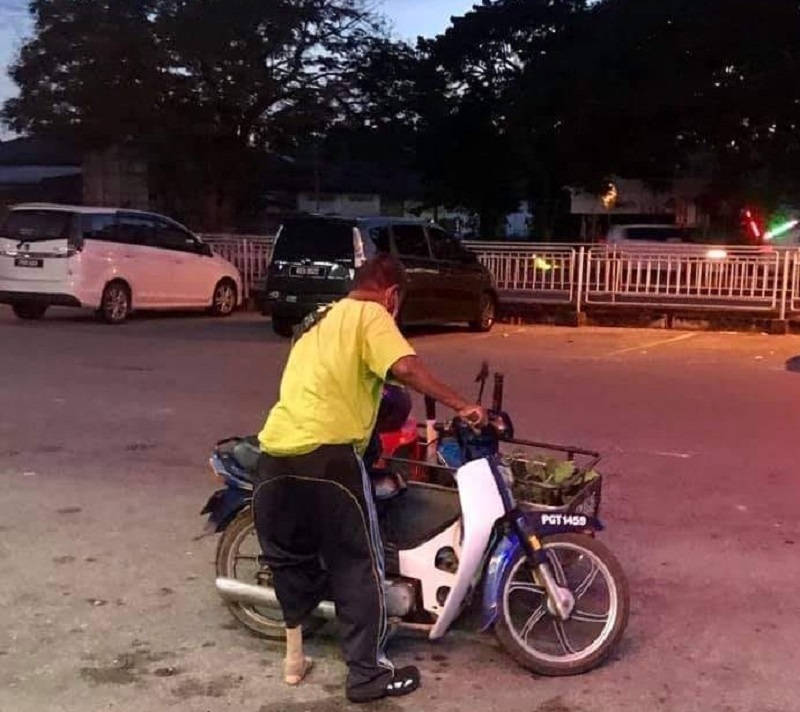 The Penang man putting the fan in his motorcycle's sidecar carrier before leaving the shop. u00e2u20acu2022 Picture via Facebook/DoktorKipas
