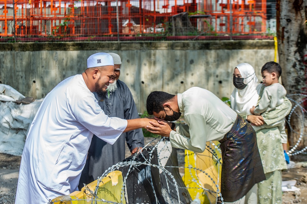 Family members greet each other at the Bandar Bukit Mahkota-Nilai border on the first day of Hari Raya Aidilfitri, May 13, 2021. u00e2u20acu2022 Picture by Shafwan Zaidon