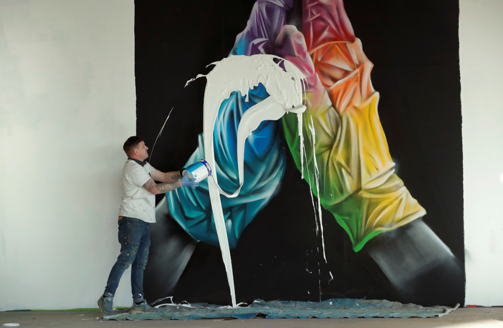 Street artist Nathan Murdoch destroys his artwork as he creates a piece of crypto art to be auctioned with proceeds donated to the NHS in Peterborough April 15, 2021. u00e2u20acu201d Reuters pic