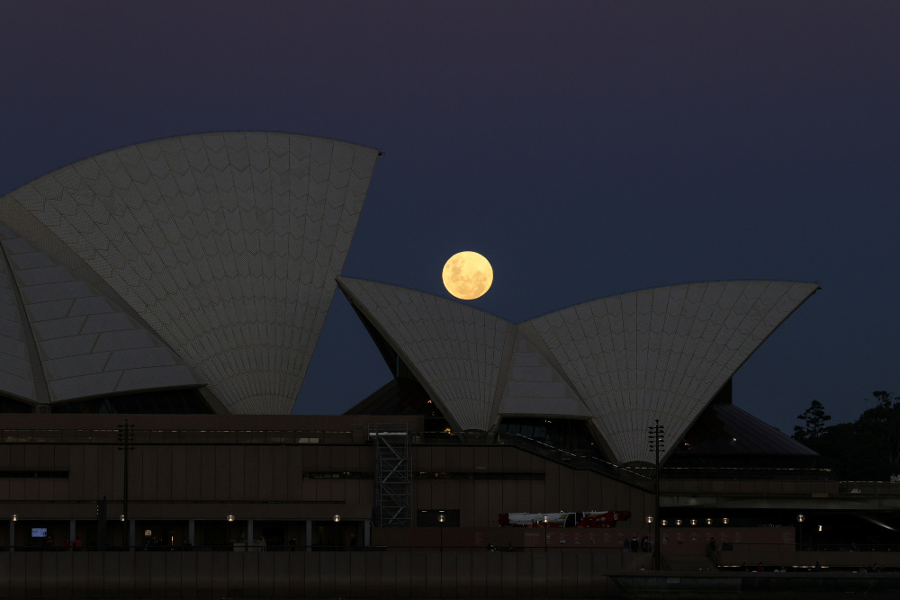 A Super Flower Moon rises behind the Sydney Opera House on the night of a lunar eclipse, in Sydney May 26, 2021. — Reuters pic