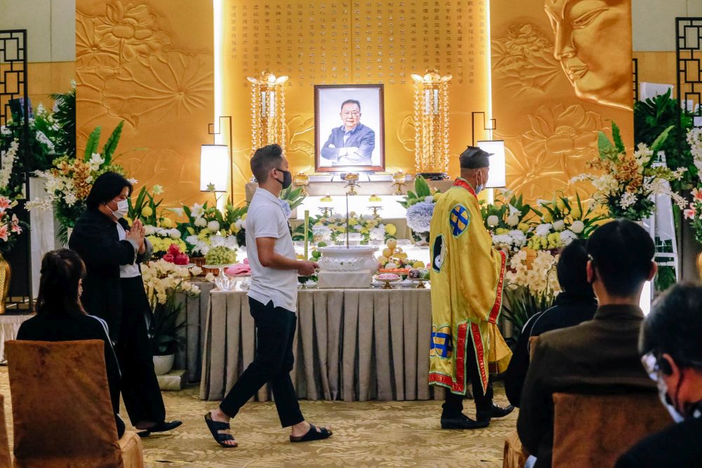 Wong Chee Mun and his sister Yik Pen circle their father’s altar and casket during the final rites at the Xiao En Centre in Jalan Kuari, Cheras May 17, 2021. — Picture by Firdaus Latif