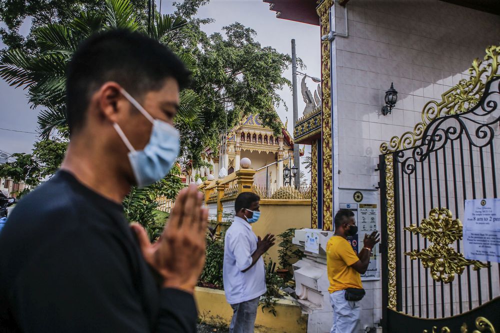 Devotees pray outside the Thai Chetawan Temple in Petaling Jaya on Wesak Day May 26, 2021. — Picture by Hari Anggara