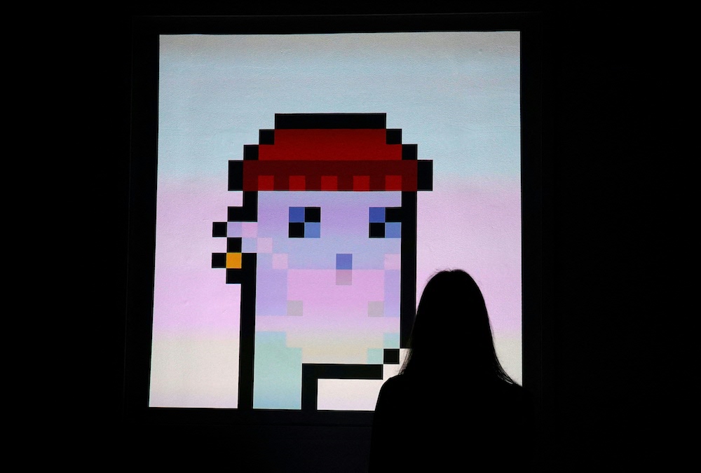 A woman looks at an NFT by Larva Labs titled u00e2u20acu02dcCryptoPunk 7523u00e2u20acu2122 during a media preview on June 4, 2021, at Sotheby's. u00e2u20acu201d AFP pic