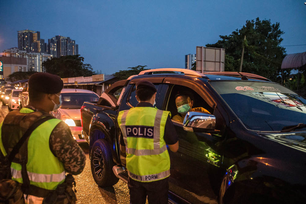 Police and Armed Forces personnel conduct checks on vehicles at a roadblock on Jalan Ipoh-Rawang June 6, 2021. u00e2u20acu201d Picture by Firdaus Latif