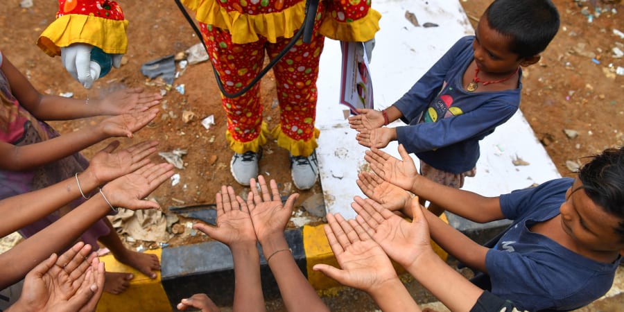 Volunteer social worker Ashok Kurmi, dressed as a clown, sprays hand sanitiser as he teaches children how to follow Covid-19 coronavirus safety protocols. u00e2u20acu201d AFP pic