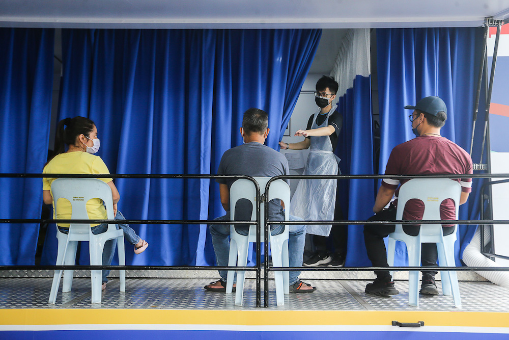 Traders and local workers at Pasar Borong Kuala Lumpur wait to receive their Covid-19 vaccination through the MYMedic@Wilayah Vaccine Mobile Truck programme in Selayang June 20, 2021. u00e2u20acu201d Picture by Yusof Mat Isa