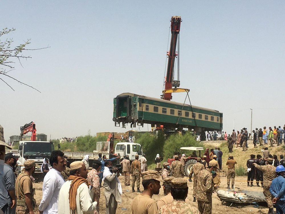 Paramilitary soldiers and residents gather as the railway workers remove a car from the site following a collision between two trains in Ghotki, Pakistan June 7, 2021. u00e2u20acu201d Reuters pic