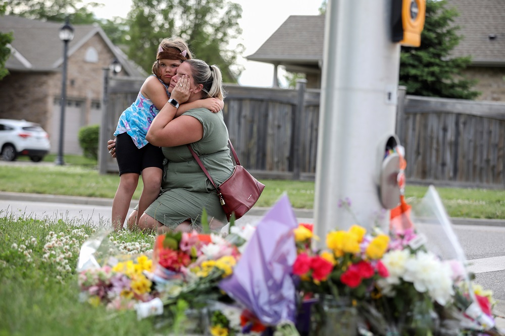 A woman and her daughter react near flowers laid at the fatal crime scene in what police say was a deliberately targeted anti-Islamic hate crime, in London, Ontario June 7, 2021. u00e2u20acu201d Reuters pic