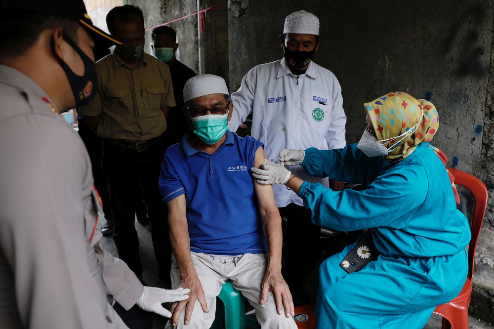 A villager of Sindanglaya receives his first dose of Chinau00e2u20acu2122s Sinovac Biotech vaccine for the coronavirus disease outside his house, during a door-to-door vaccination in Cianjur regency, West Java province June 15, 2021. u00e2u20acu201d Reuters pic