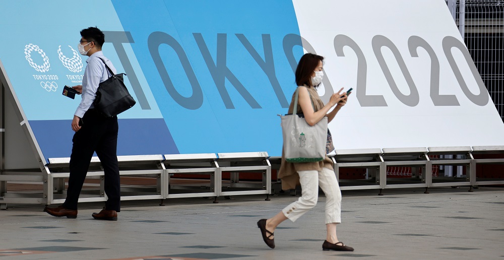 People walk past a sign for the 2020 Tokyo Olympic Games that have been postponed to 2021 due to the coronavirus disease pandemic, at the IBC/MPC media centre at Tokyo Big Sight exhibition centre in Tokyo June 30, 2021. u00e2u20acu201d Reuters pic