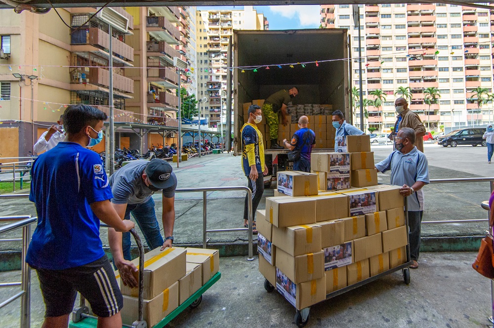 Local residents unload boxes of food aid at PPR Sri Sarawak, Kuala Lumpur on June 1, 2021. — Picture by Shafwan Zaidon