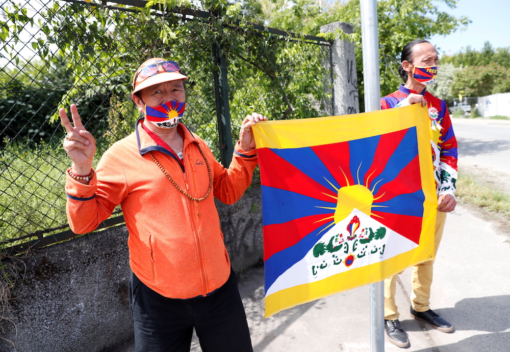 Activists hold a Tibetan flag next to a street sign in a street renamed 'Martyrs of Uyghur', near the planned site of Chinese Fudan University campus, in Budapest, Hungary, June 2, 2021. u00e2u20acu201d Reuters pic 