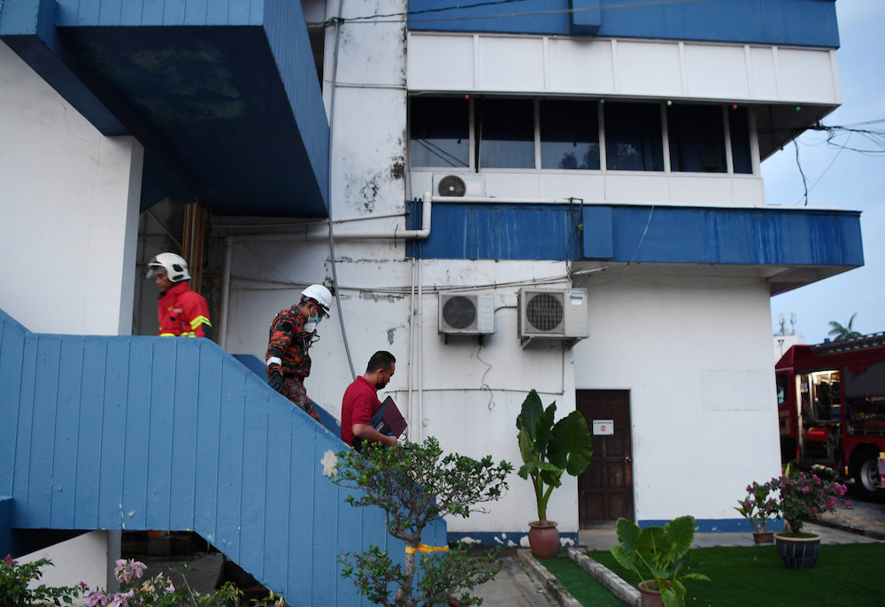 nPolicemen are seen carrying out computers saved from the fire on the third floor of the Kuantan CID as firemen arrive to control the blaze. June 6, 2021. u00e2u20acu201d Bernama picn