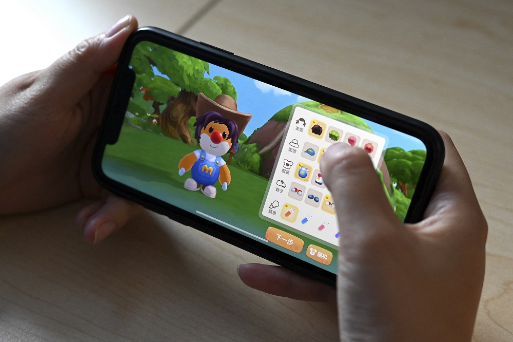 A photo illustration shows a user playing the 'Moleu00e2u20acu2122s World' game on a smartphone in Beijing. u00e2u20acu201d AFP pic