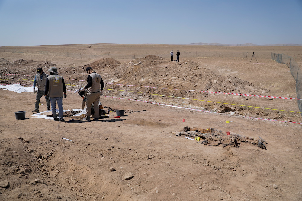Employees of Iraq's Ministry of Health collect the remains of bodies of people who, according to Iraqi officials, were killed by Islamic state militants, during the exhumation of a mass grave in Mosul, Iraq June 13, 2021. u00e2u20acu201d Reuters pic