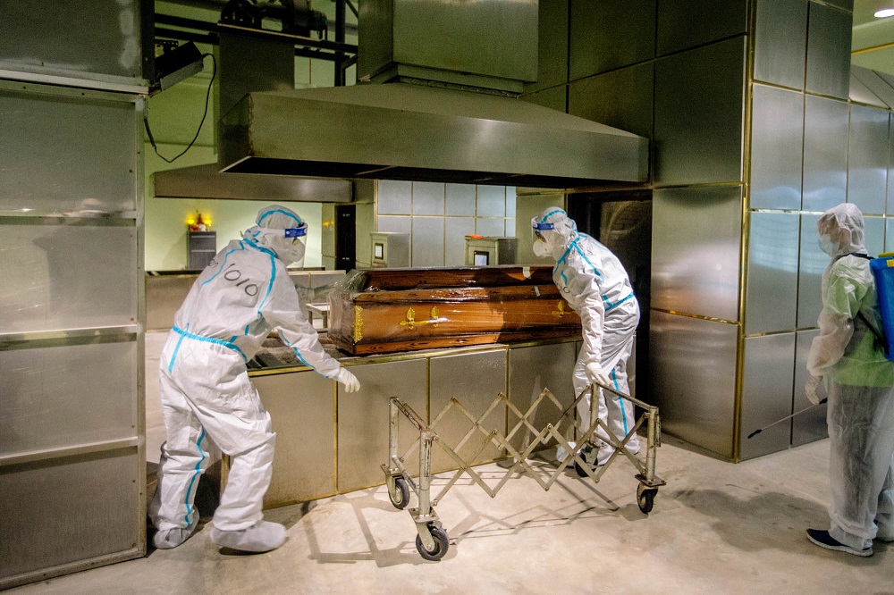 Workers tend to a casket containing the body of a Covid-19 victim at a funeral parlour in Shah Alam June 15, 2021. u00e2u20acu201d Picture By Firdaus Latif