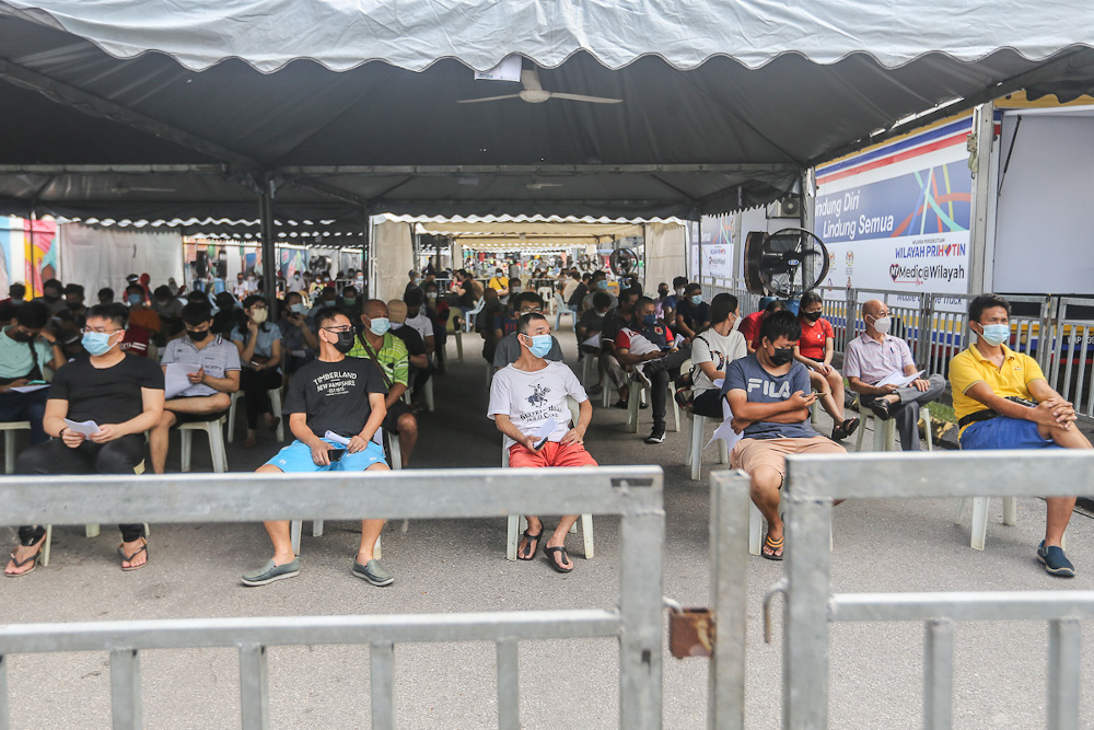 Traders and workers at Pasar Borong Kuala Lumpur queue to receive their Covid-19 vaccination through the MYMedic@Wilayah Vaccine Mobile Truck programme in Selayang June 20, 2021. — Picture by Yusof Mat Isa  