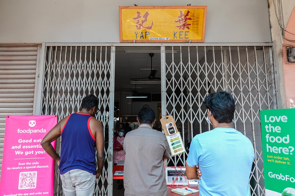 Customers wait at the entrance of Yap Kee kopitiam in Klang June 23, 2021. 