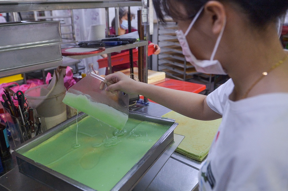 A  Meru Golden Bake worker prepares their signature Pandan Layer cake to be distributed to several bakery shops owned by the other family members in Klang June 23, 2021.