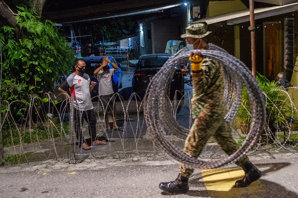 A member of the Malaysian Armed Forces is seen installing a barbed wire fence at Kampung Segambut Dalam in Kuala Lumpur June 25, 2021. u00e2u20acu201d Picture by Shafwan Zaidon 